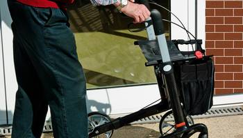 Aktiv und fit mit dem Rollator Ein älterer Herr geht mit einem Rollator.